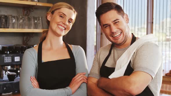 Cheerful owners standing with arms crossed