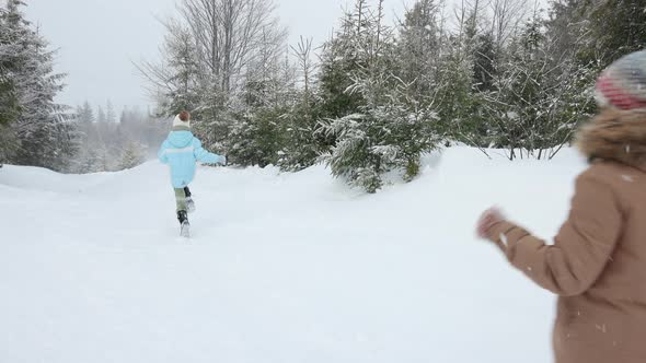 Happy Kids Running on Snowy Spruce Forest