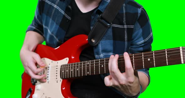 Mid section of male musician playing guitar