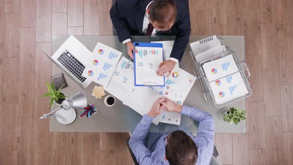 Top View of Businessman in Suit Signing a Contract After Analysing Agreement Charts