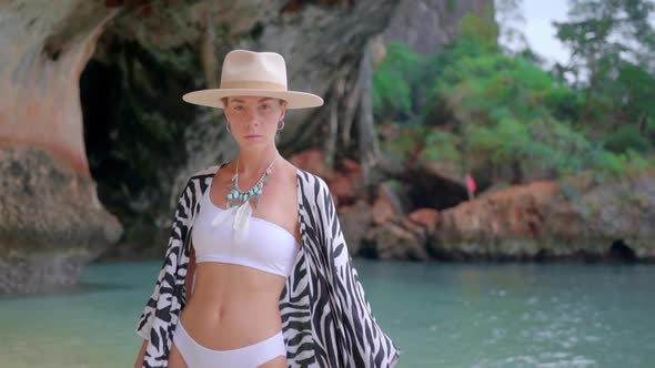 Brunette Female Model Posing on the Beach of Krabi Against Amassing Blue Lagoon and Cave
