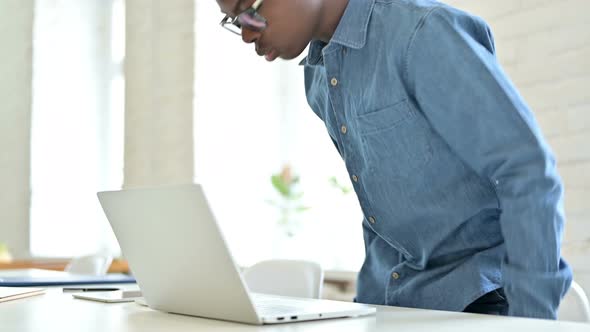 Young African Man Coming Back and Working on Laptop