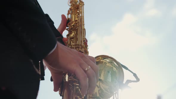 Musician Saxophonist Plays Music on His Instrument in a Sunny Summer Day