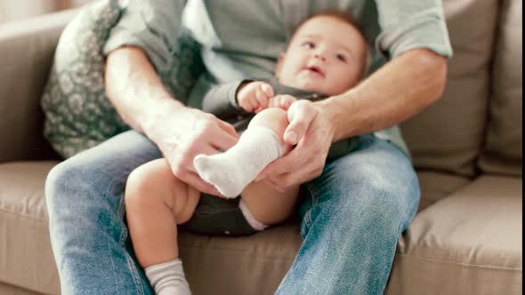 Father Putting Sock on Baby Daughters Foot 5