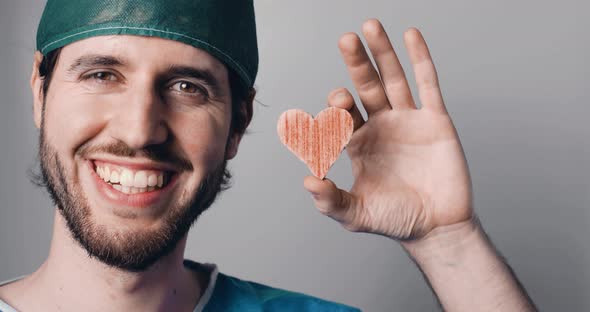Happy Doctor Holds the Heart Symbol in his Hand