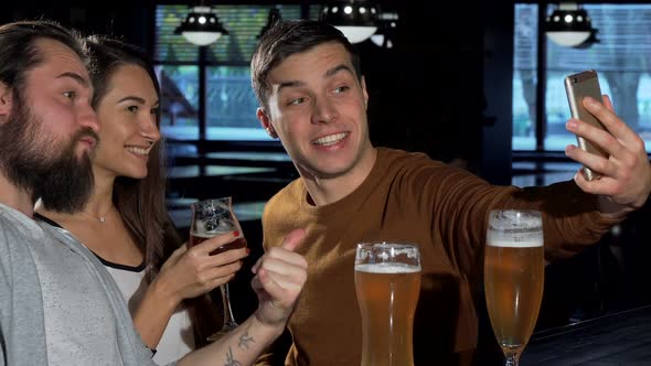 Group of Friends Taking Selfies with Smart Phone, While Drinking Beer Together