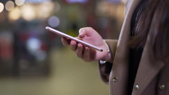 Girl Uses the Phone Outdoors Close-up