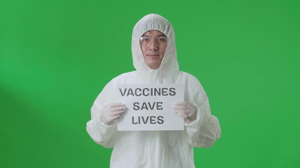 Asian Man Wear Uniform Ppe And Holding Vaccines Save Lives Sign In The Green Screen Studio