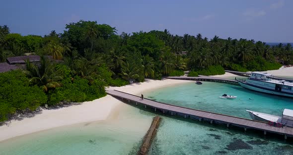 Daytime fly over island view of a white paradise beach and aqua blue water background in best qualit