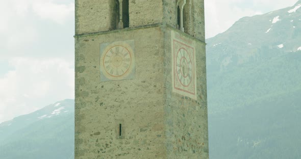 Zoom in shot, Scenic view of Clock on Kirchturm von Altgraun in Italy, Mountain range in the backgro