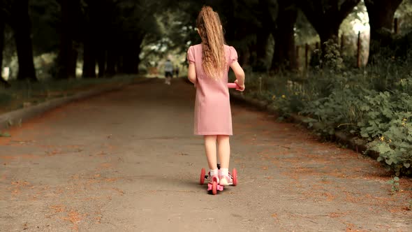 Small Girl Riding On Scooter. Kid Girl Playing On Park. Daughter Enjoy Ride Kick Scooter Outdoor.