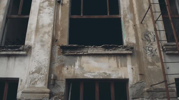 Motion Up Along Abandoned Building with Rusty Fire Stairs