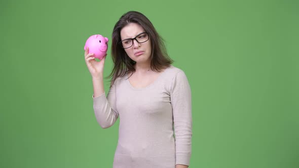 Young Beautiful Woman Shaking Piggy Bank