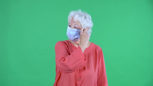 Portrait Elderly Woman Looking at the Camera and Removing the Medical Mask