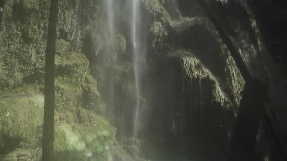 Tilt down to reveal people bathing in Tumalog falls.
