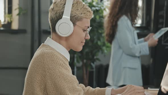 Young Woman in Headphones at Coworking Office