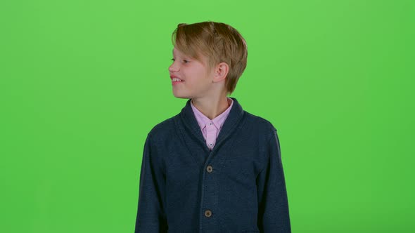 Teenager with Interest Looks Around and Then Shows a Credit Card on a Green Screen