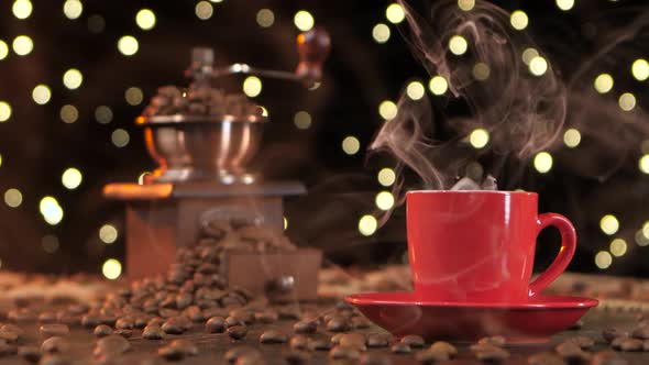Red Cup of Hot Coffee with Smoke and Coffee Grinder