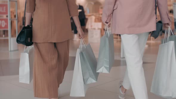 Unrecognizable Women Walking into Clothes Shop