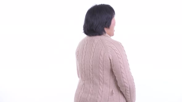 Rear View of Happy Overweight Asian Woman Thinking and Looking Around in Winter