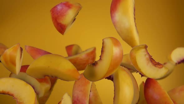 Slices of the Fresh Ripe Peach Are Bouncing on the Yellow Background