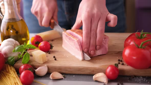 Making Pasta Carbonara Slicing Traditional Pancetta Bacon Into Pieces on a Wooden Cutting Board with