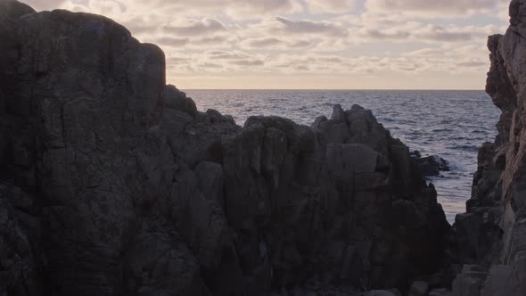 Sunset over ocean from a canyon at golden hour. Static shot in slow motion.