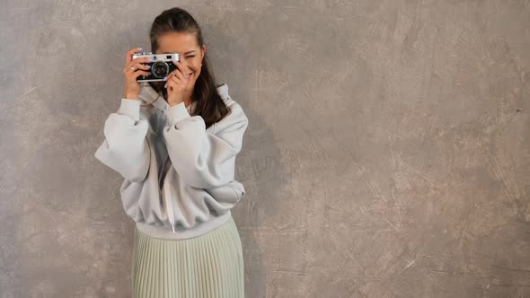 Beautiful young photographer girl taking photos using her retro camera