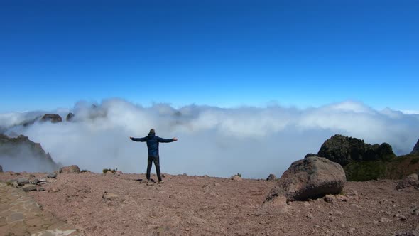 Man with arms wide open on Pico do Arieiro to Pico Ruivo hike, Madeira