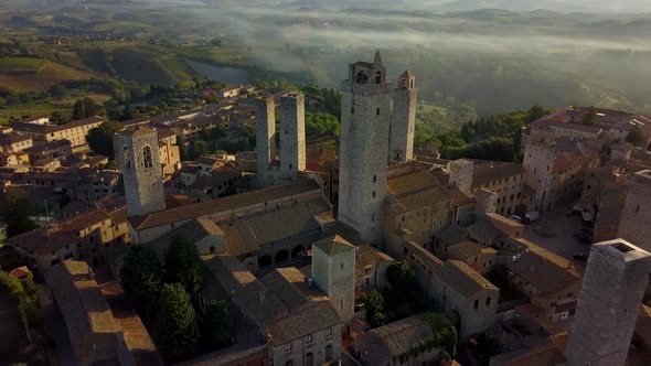 Town of San Gimignano Italy close up of Torre Grossa and San Gimignan basilica left, Aerial dolly ou