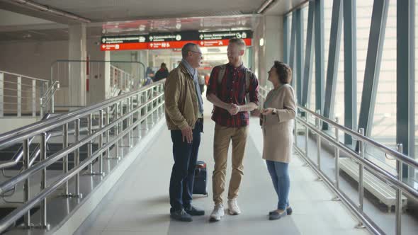 Portrait of Three People of Different Age Standing with Luggage at Railway Station