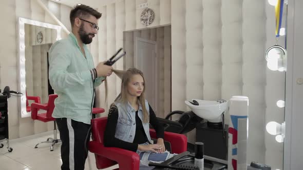 Professional Hairdresser Working with Model Hair. Straightening Corrugated Iron