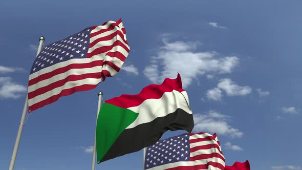 Waving Flags of Sudan and the USA on Sky Background alt