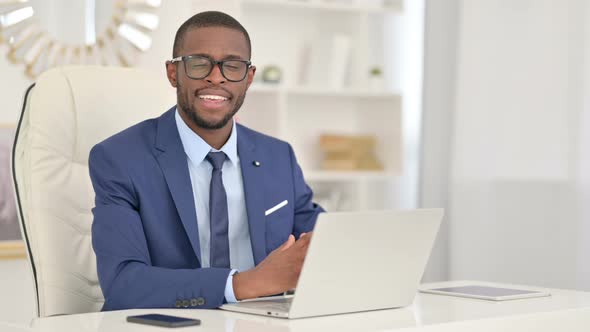 Young African Businessman with Laptop Smiling at the Camera 