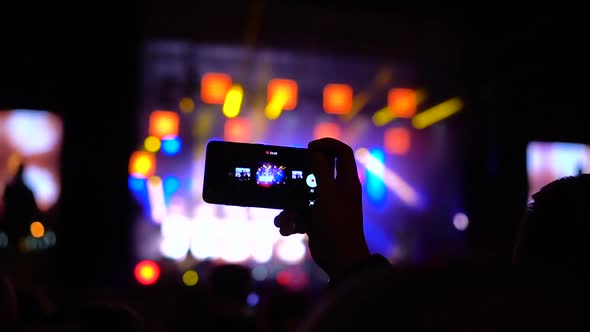 Close Up of Hands with Mobile Phone Shooting Video and Taking Photo at Music Concert