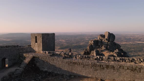 Drone flying over Monsanto ruins viewpoint at sunrise, Portugal. Aerial forward