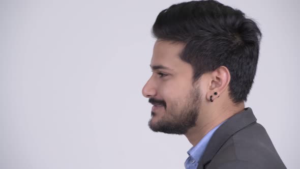 Profile View of Young Happy Bearded Indian Businessman Talking