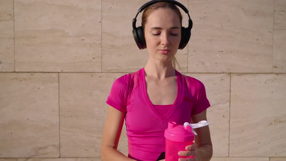 Thirst After Morning Jog Young Sporty Woman is Drinking Water From Reusable Bottle in City Street