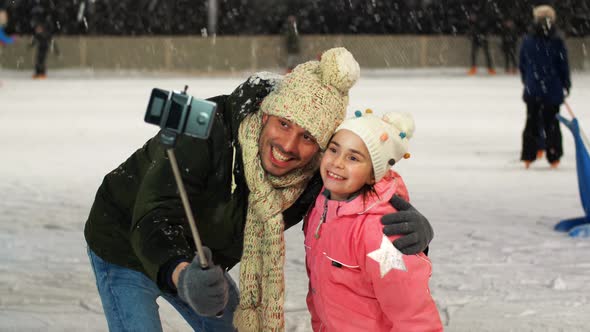 Father and Daughter Taking Selfie on Skating Rink