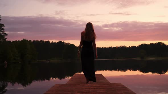 Dreamy Lady Enjoying Orange Sunset By the Lake in a Pier