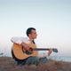 Alone Man Playing Guitar Sitting on the Coast - VideoHive Item for Sale