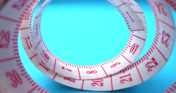 Super Macro Shot of a Measuring Tape Into a Roll of Sewing and Colored Thread on the Background Blue