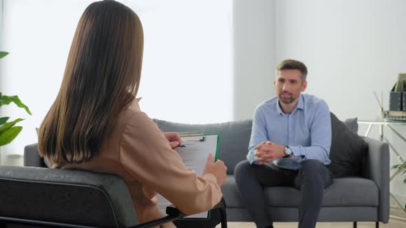 Woman Psychologist Taking Notes on Clipboard Listen Man at Psychotherapy Session