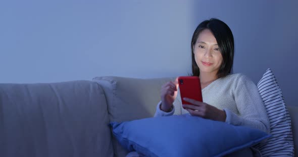 Woman use of cellphone at home in the evening