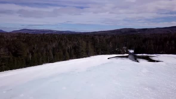 Get an aerial view of Ice Fishing on Fitzgerald Pond, Maine. Mullen Brook flows into the pond creati