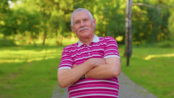 Happy Lovely Senior Old Grayhaired Grandfather in Casual Red Tshirt on Summer Park Background