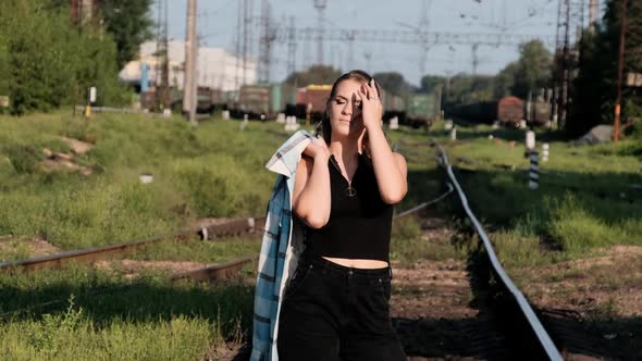 Young Sexy Woman Stands on the Train Tracks and Looks at the Camera