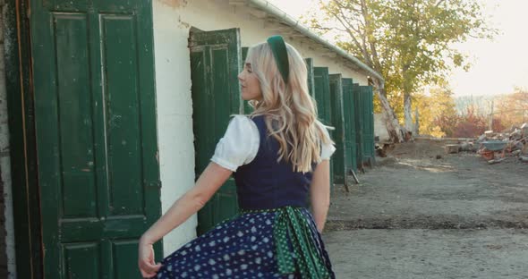 Beautiful Blonde in Ethnic Dress Poses and Whirls at Near Stable in Rural Place