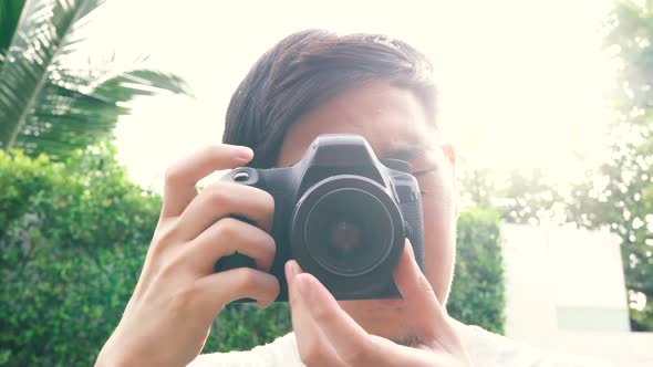 Young Male Photographer Taking Photos During Sunset with Backlighting Lens Flare From Behind