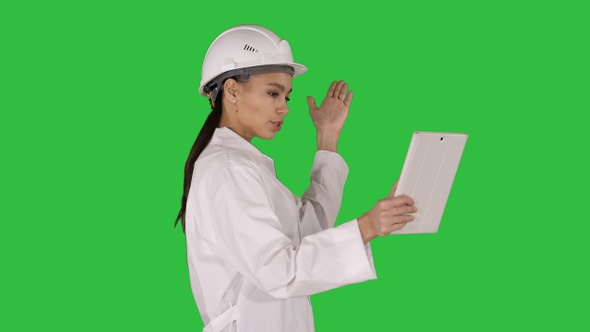 Woman engineer with tablet making video call on a Green